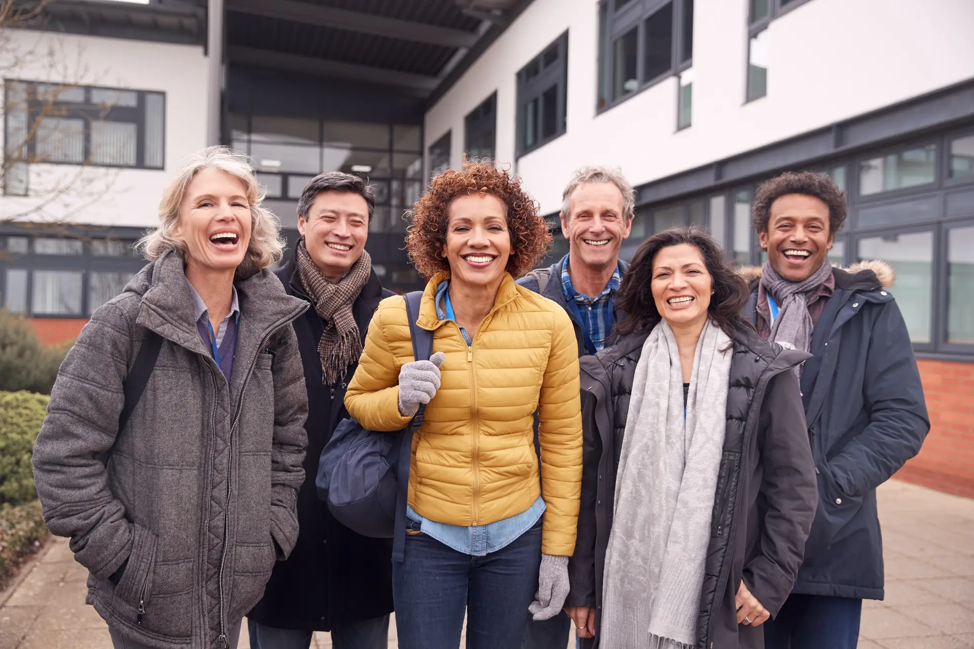 Portrait Of Group Of Smiling Mature Students Standing Outside College Building